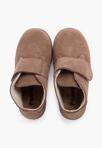 Scarpe per bambini in suede marrone, con cinturini regolabili in Velcro e fodera morbida, viste dall'alto su uno sfondo bianco.