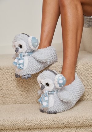 Gray plush owl slippers with blue accents, polka dot scarf, and glittery soles, featuring soft fabric and round eyes.