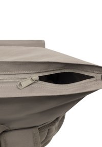 Zaino in tessuto grigio con chiusura a cerniera in alto, caratterizzato da una superficie testurizzata e bordi rinforzati. La fodera interna è visibile.