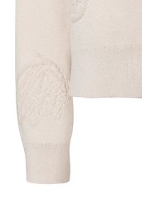 Hellbeiger Strickpullover mit strukturierten Blumenverzierungen am Ärmel, ausgestattet mit einem gerippten Bündchen und einem glatten Körper.