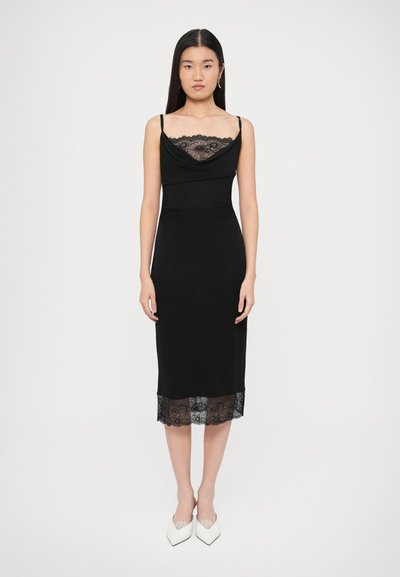 Schwarzes, figurbetontes Kleid mit Wasserfallausschnitt und Spitzenverzierung am Saum, mit dünnen Trägern und durchgehend glatter Textur.