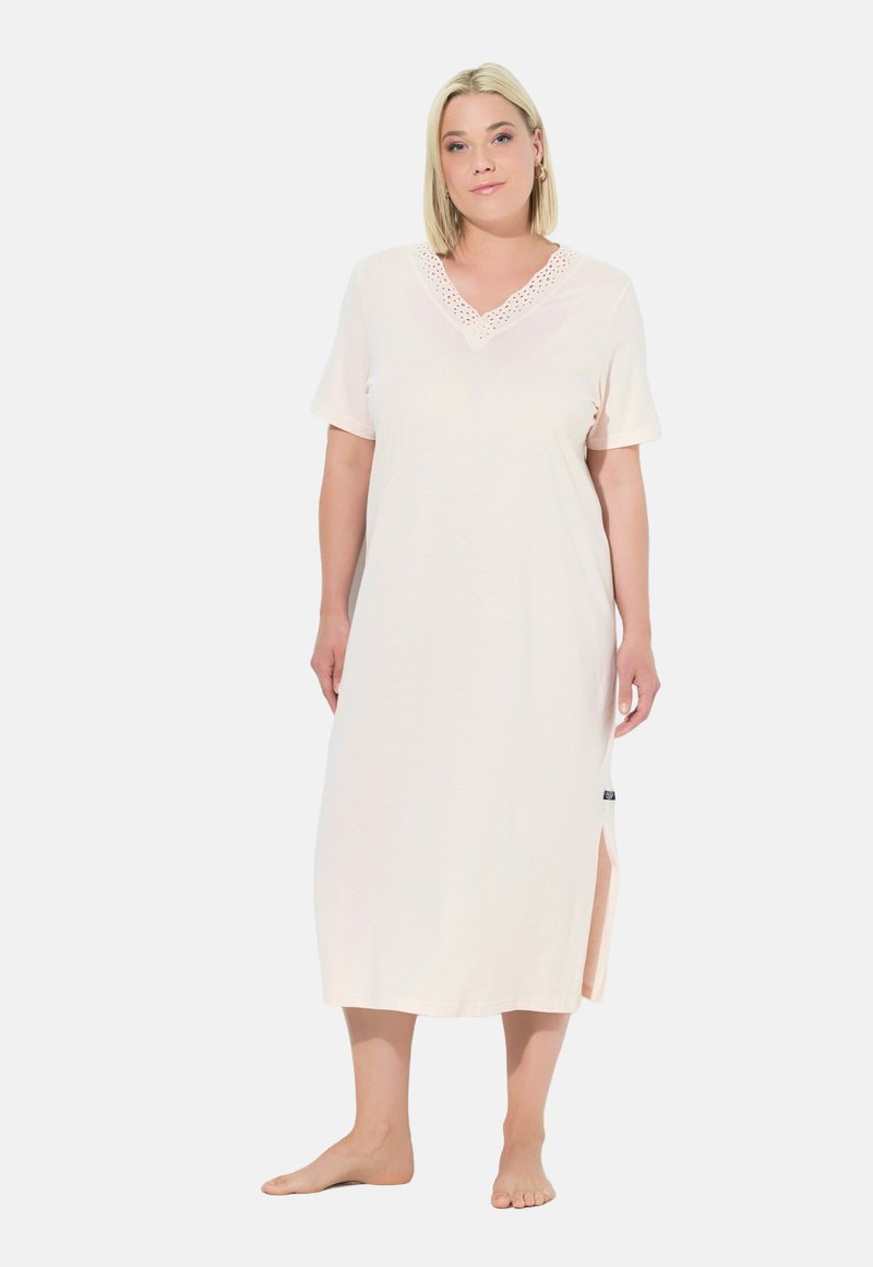 Camicia da notte rosa chiaro realizzata in tessuto morbido, con scollatura a V decorata con dettagli in pizzo, maniche corte e fessure laterali per un maggiore comfort.