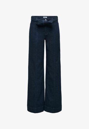 Temno modre široke kavbojke z visokim pasom, zavihanim robom in pasom iz iste tkanine, vezanim v pentljo na pasu.