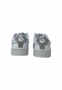 Sneakers bianchi con un accentuato tacco metallico argento texturizzato. Presentano una suola in gomma spessa e un logo sul retro.