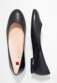 Black leather ballet flats with a rounded toe, low heel, and a smooth texture. Interior shows a light-colored insole with embossed branding.