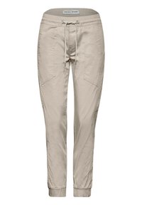 Beige joggarbyxor gjorda av mjukt tyg, med elastisk midja och snörning, sidofickor och åtsittande muddar vid anklarna.