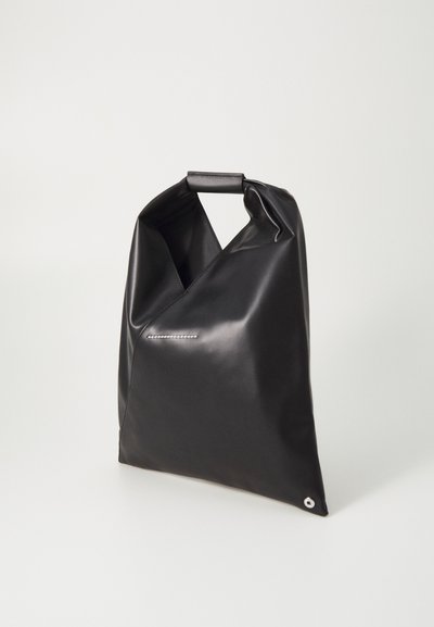 Črna, mehka torba, ki se zloži in ima ročaj, s sleek dizajnom in minimalističnim dekorativnim šivom. Vsebuje majhen kovinski detajl.