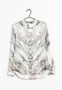 Blusa a maniche lunghe in colori chiari con motivi astratti intricati. Presenta un scollo a V e un orlo arrotondato, realizzata in tessuto morbido.