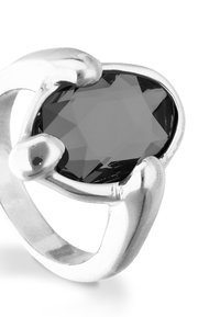 Bague en argent avec une grande pierre noire facettée, entourée d'accents métalliques lisses et courbes. Finition polie, design moderne.