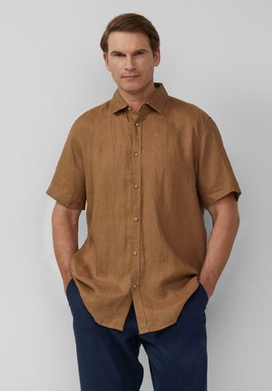Chemise en lin marron à manches courtes avec col boutonné, présentant une coupe décontractée et une surface légèrement texturée.