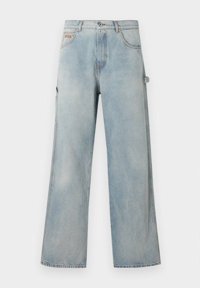 Pantalon en jean bleu clair à jambes larges avec cinq poches, fermeture à boutons et une boucle sur le côté droit pour outils ou accessoires.