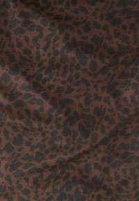 Brązowa tkanina w czarny wzór w cętki lamparta. Miękka tekstura z plamkami i rozpryskami o różnych rozmiarach rozmieszczonymi w całym wzorze.