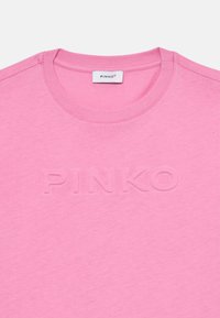 Różowa bawełniana koszulka z okrągłym dekoltem, z wypukłym logo "PINKO" z przodu. Gładka faktura, casualowy design.
