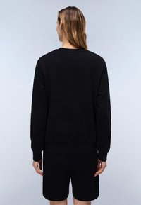 Czarny sweatshirt z długimi rękawami i ściągaczami, prezentowany z tyłu. Materiał wydaje się gładki i lekko elastyczny, w zestawie z dopasowanymi szortami.