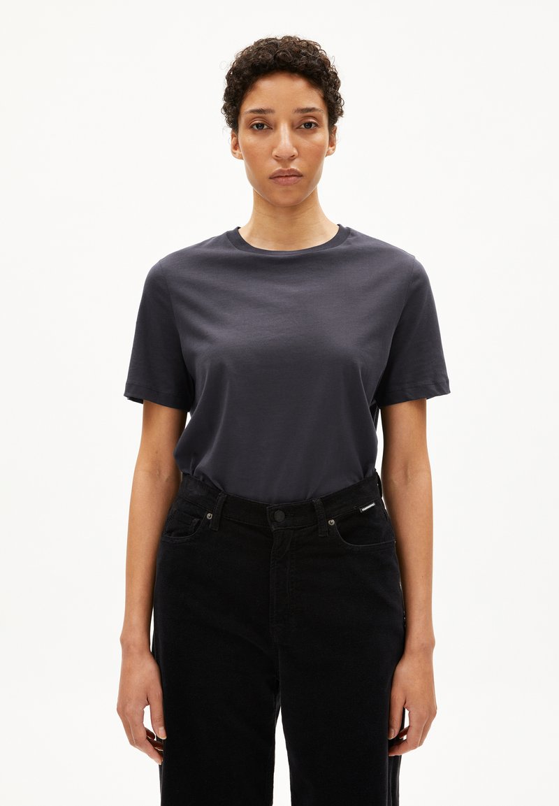 Donkergrijze katoenen t-shirt met korte mouwen en een ronde hals, gecombineerd met hoge zwarte spijkerbroek. Soepele textuur, casual pasvorm.