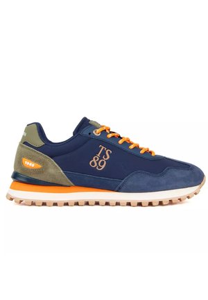 Marineblauwe sneaker met oranje veters, beige en groene suède accenten, "TS 89" logo aan de zijkant en dikke profielzool met oranje streep.