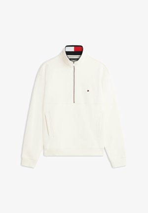 Ecru bluza z zamkiem sięgającym do ćwiartki z prążkowanymi mankietami i dołem, dwoma przednimi kieszeniami oraz małym logo Tommy Hilfiger na piersi.