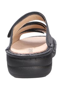 Black sandal with three cut-out straps and a rounded toe. Features a cushioned footbed and a smooth, slightly textured sole.
