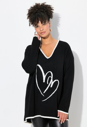 Schwarzer übergroßer Pullover mit weißem V-Ausschnitt und Herzdesign. Weicher Stoff, lange Ärmel und abgerundeter Saum.