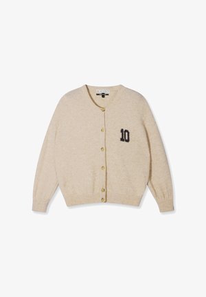 Beige knopen-up vest met lange mouwen en een zwarte "10" gedrukt op de linkerkant van de borst, geribbelde manchetten en zoom.