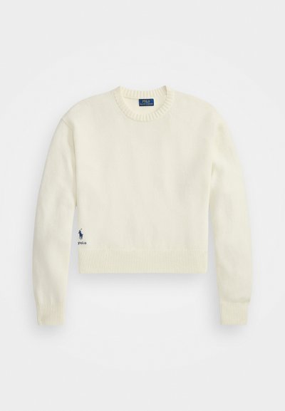 Kremowy krótki sweter wykonany z miękkiego materiału. Posiada rygorystyczny dekolt i dół, z małym niebieskim logo po lewej stronie.