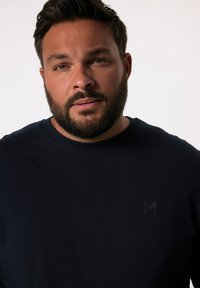 Granatowa, krótko-sleeve koszulka z miękkiego materiału, z delikatnym czarnym logo na piersi i klasycznym okrągłym dekoltem.