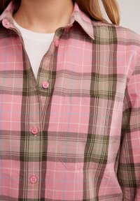 Camicia a righe con colori rosa, verde e marrone. Presenta un colletto, una tasca a toppa e bottoni rosa. Realizzata in cotone, dal design informale.