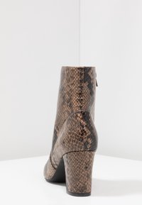 Brown snake-print ankle boot with a tapered, textured leather upper and a block heel, featuring a smooth finish and subtle stitching details.