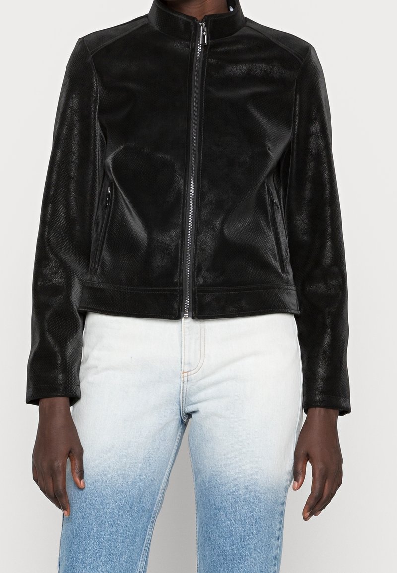 Veste en cuir noir avec un col haut, surface texturée et zip sur le devant. Elle comporte deux poches latérales et des manches ajustées.