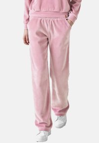 Rosa Velours-Sweatpants mit entspannter Passform, featuring einen elastischen Bund und seitlichen Taschen. Glatte Textur mit einem dezenten Glanz.
