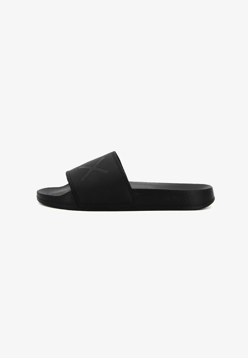 Black slide sandals with wide top strap, made of smooth rubber, featuring a raised logo design and flat, textured sole for grip.