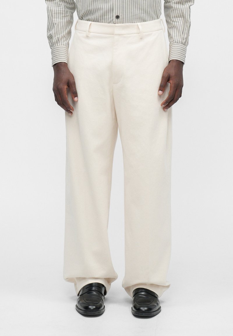 Kremfargede bukser med vide ben laget av et mykt stoff, med et rent design som har en jevn tekstur og subtile folder.