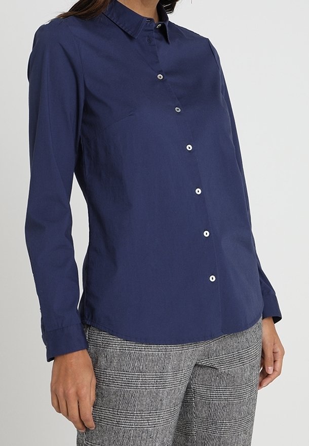 Camicia abbottonata blu navy realizzata in tessuto liscio, con colletto e maniche lunghe con polsini abbottonati, che presenta una leggera lucentezza.