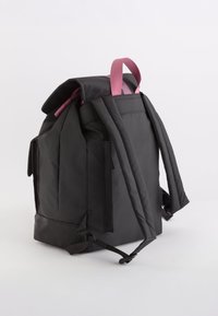 Mochila de tela negra con correas rosa. Cuenta con una forma estructurada, correas acolchadas, bolsillos laterales y un cierre en la parte superior.