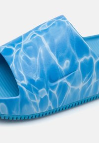 Zilā slīdvirsma ar teksturētu virsmu, uz kuras ir ūdens raksts, atvērta purngala un rievota zole labākai saķerei. Izgatavots no viegla materiāla.