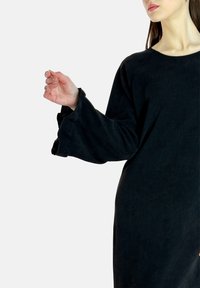 Robe noire côtelée avec manches longues amples ornées d'accents texturés. Le tissu semble doux avec une finition légèrement brillante.