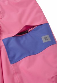 Rosa Stoff mit einer blauen, abgerundeten Tasche, die mit einem Reißverschluss gesichert ist. Beinhaltet ein kleines graues Logoetikett im Taschenbereich.