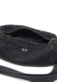 Black canvas shoulder bag with zip closure, embossed "DIESEL" label inside, and a silver logo accent on the front. Textured surface.