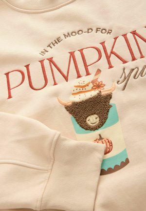 Cream-colored sweatshirt featuring embroidered text and a design of a cup topped with a bear, decorated with a pumpkin and stripes.