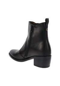Stivale alla caviglia in pelle nera con zip laterale e tacco largo basso, con una linguetta sul retro.