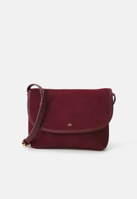 Sac en cuir suédé bordeaux à bandoulière avec quincaillerie dorée, rabat repliable et bandoulière en cuir réglable. Texture douce et design minimaliste.