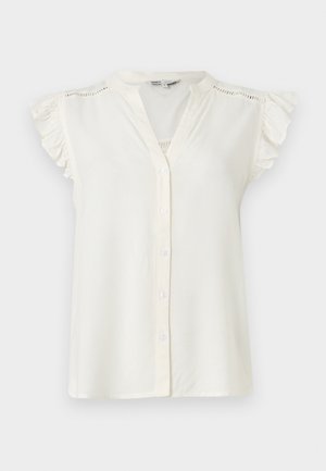 Biała bluzka bez rękawów z guzikami z przodu, falbankowate rękawy typu „kapelusz” oraz delikatne koronkowe zdobienia wzdłuż ramion i dekoltu.