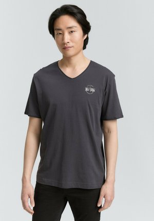 Dunkelgraues Baumwoll-T-Shirt mit V-Ausschnitt, kurzen Ärmeln und einem kleinen Logo auf der linken Brust. Einfaches und lässiges Design.