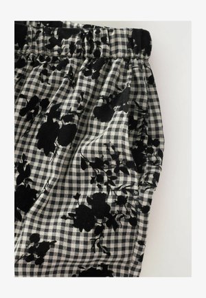 Schwarz-weißer Karostoff mit floralen Mustern, ausgestattet mit einem gerafften Taillenbund und weicher Textur.