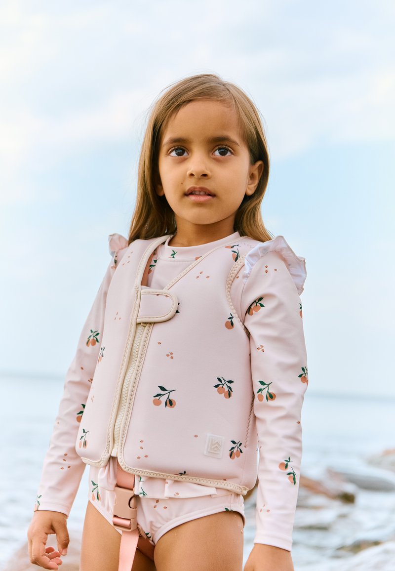 Chaleco salvavidas rosa con estampado floral, mangas con volantes, cierre de cremallera y traje de baño a juego. Presenta patrones naranjas y verdes sobre un material suave y elástico.
