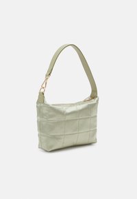 Ljusgrön quiltad axelväska med bred rem och gyllene spänne på enfärgad vit bakgrund.