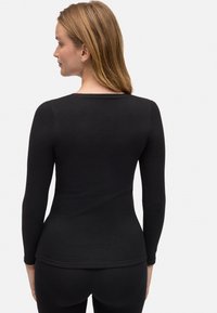 Top negro de manga larga hecho de tela elástica, con un cuello redondeado y un diseño ajustado, de textura suave y costuras mínimas.