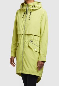 Ljust grön vattentät jacka med dragkedja framtill, justerbar huva och elastisk midja, med en lockficka och manschettdetaljer.