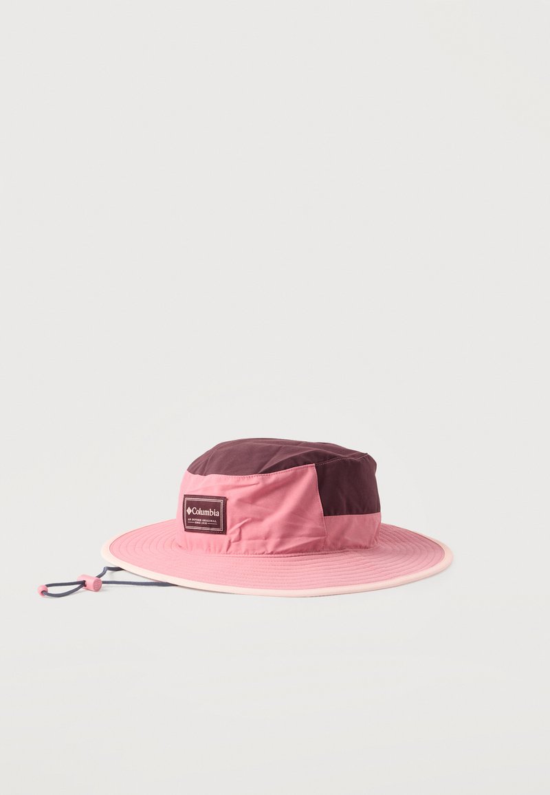 Εξωτερικό καπέλο με πλατύ γείσο σε δύο αποχρώσεις ροζ και βουργουνδί, με ρυθμιζόμενο λουράκι στο πιγούνι και ετικέτα με το λογότυπο Columbia στο μπροστινό μέρος.