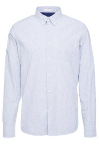 Camisa de botones de manga larga de corte ajustado con rayas verticales en azul claro y blanco, con cuello abotonado y bolsillo en el pecho.